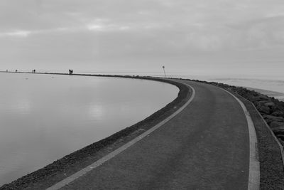 Road by sea against sky