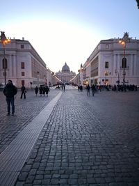 People on street amidst buildings in city