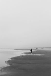 Man on beach against clear sky