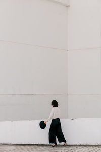 Side view of woman standing against wall