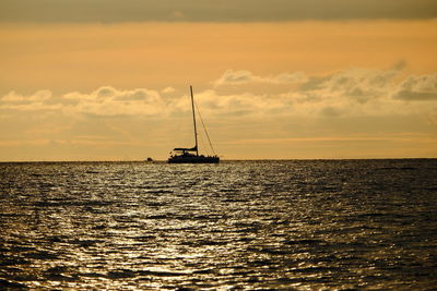 Silhouette sailboat on sea against sky during sunset