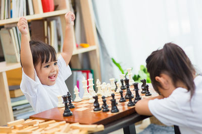 Siblings playing chess at home