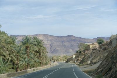 Road by mountain against sky
