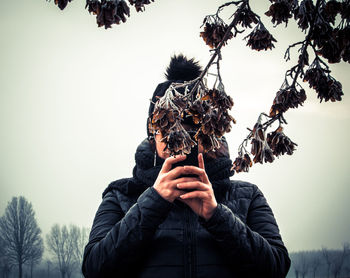 Portrait of person photographing against sky