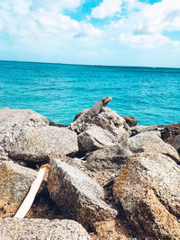 Scenic view of rocks on beach against sky
