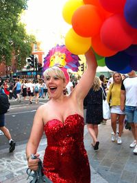 Woman standing with balloons in city