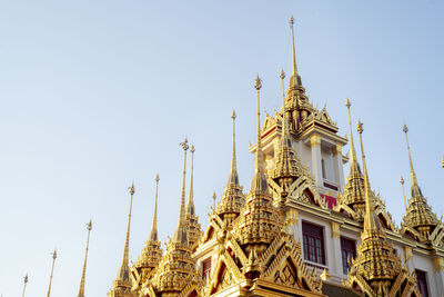 The golden sparkling roof of beautiful temple in the sunlight and blue sky.