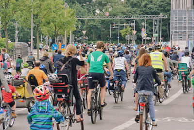 Rear view of people walking on road in city