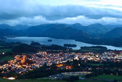 High angle view of illuminated city by buildings against sky