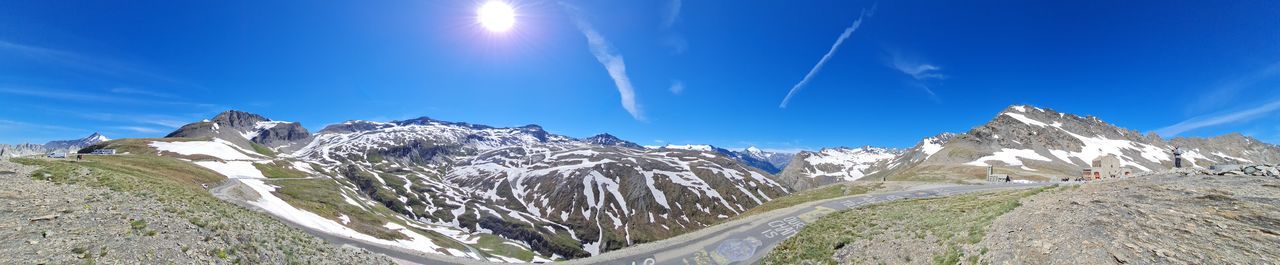 Panoramic view of snowcapped mountains against blue sky