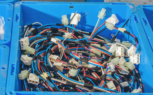 Blue container with bunch of colored cables, connections, wires. industrial background.