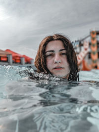 Portrait of young woman swimming in pool