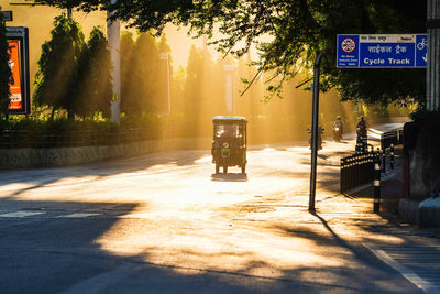 Beautiful sun rays touching of raipur, an electrical auto rikshaw passing in empty road 