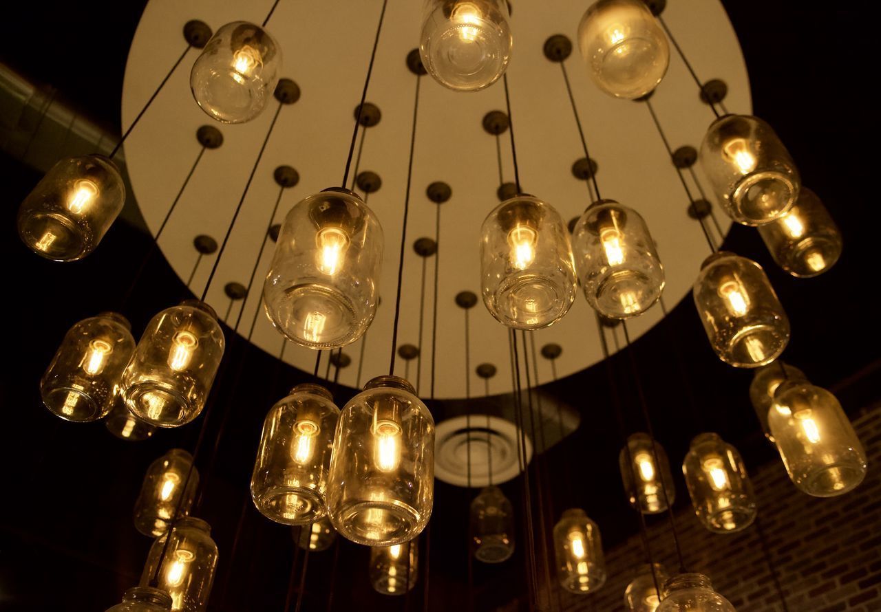 LOW ANGLE VIEW OF ILLUMINATED PENDANT LIGHTS HANGING AT HOME