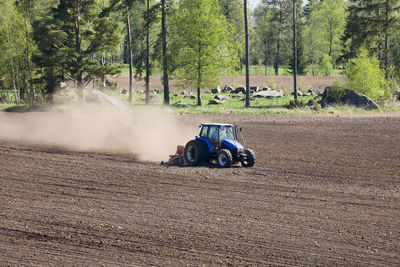 Tractor harrows on a field