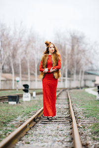 Portrait of woman standing on railroad track