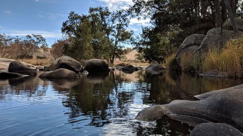 Reflection of rocks in lake against sky