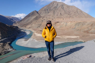 Full length portrait of woman standing on mountain