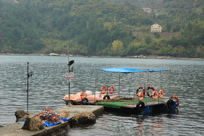 People in boat on river against trees