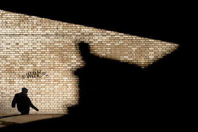 Shadow of person sitting on wall