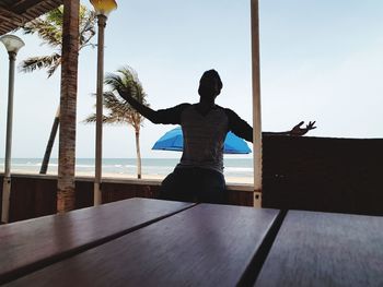 Rear view of man standing on beach