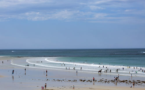 Group of people on beach against sky