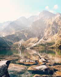 Scenic view of lake by mountains against sky