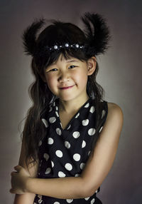 Portrait of smiling girl against gray background