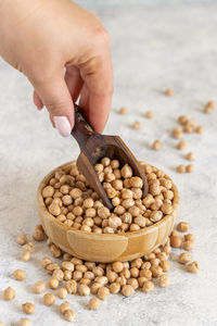 Hand with a scoop of raw dry chickpea close up