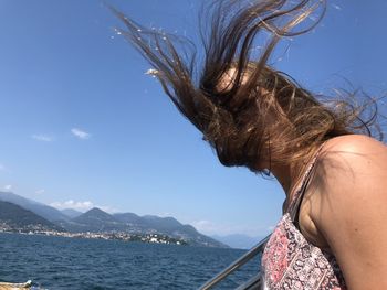 Midsection of woman in sea against sky