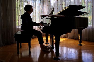 Senior woman playing piano at home