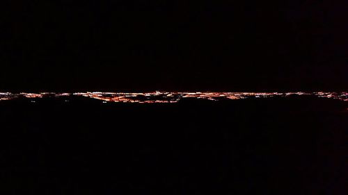 Close-up of illuminated lights against sky at night