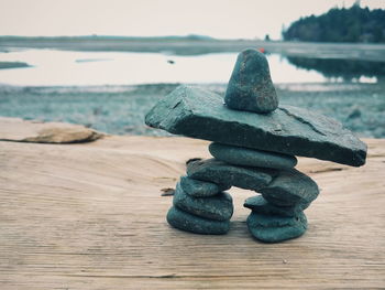 Close-up of stack of wood on sea against sky