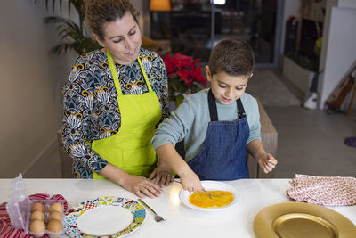 Mother and son making croquettes in the kitchen