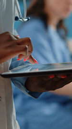 Midsection of doctor examining patient in hospital