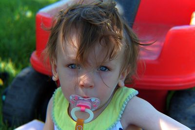 Close-up portrait of cute baby girl with pacifier in mouth 