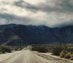 Road amidst mountains against sky