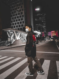 Man standing on road at night