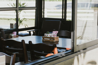 Empty chairs and table in restaurant seen through window