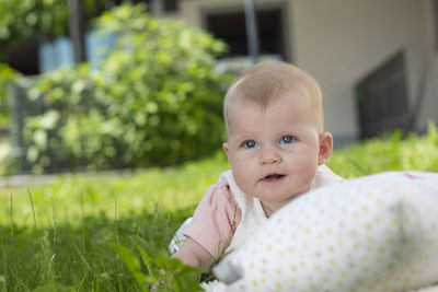 Cute baby boy lying on field