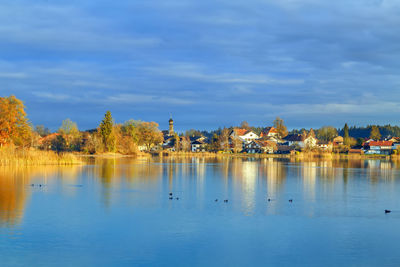 Scenic view of lake by buildings against sky