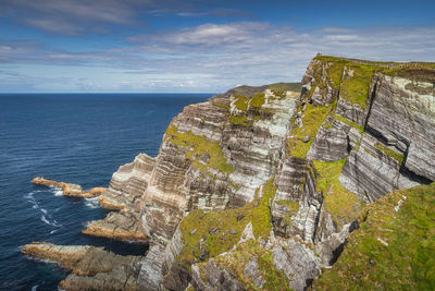 Tourists standing on the top of majestic  kerry cliffs with a view on atlantic ocean, ireland