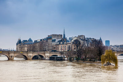 Bridge over river against buildings in city