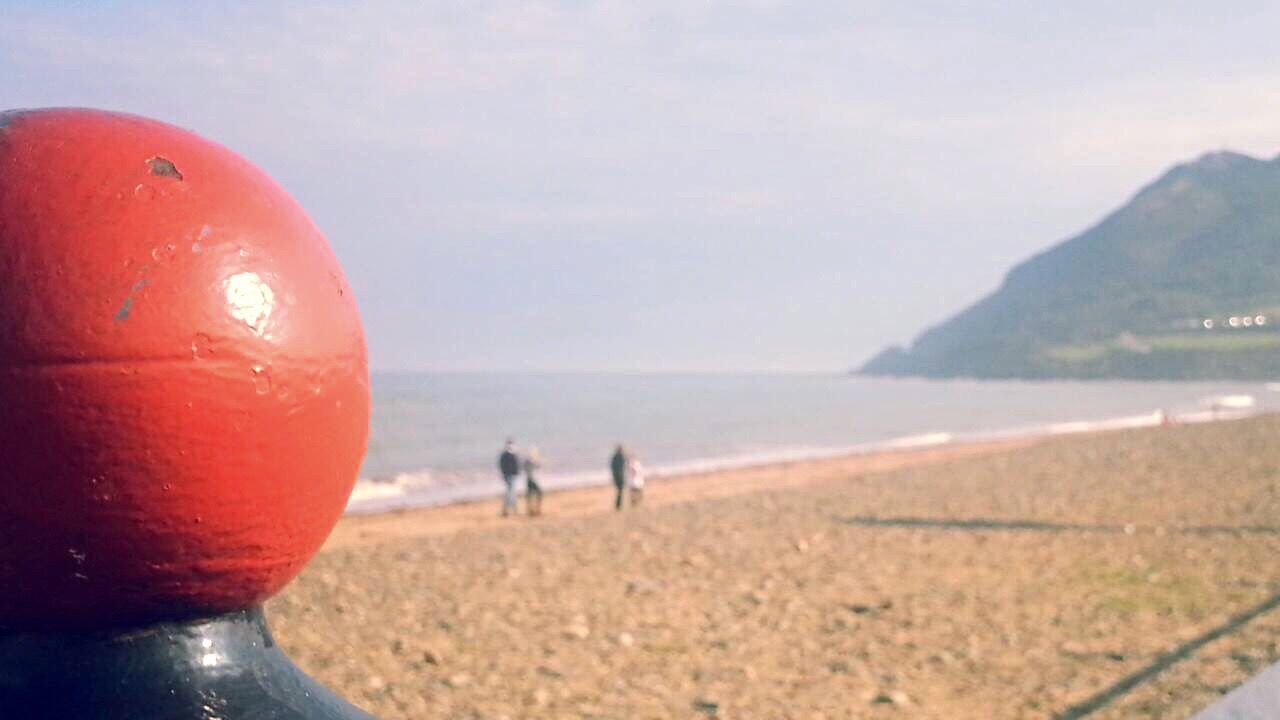 sea, beach, water, horizon over water, red, sky, shore, leisure activity, scenics, lifestyles, sand, tranquil scene, beauty in nature, nature, focus on foreground, mountain, close-up, part of