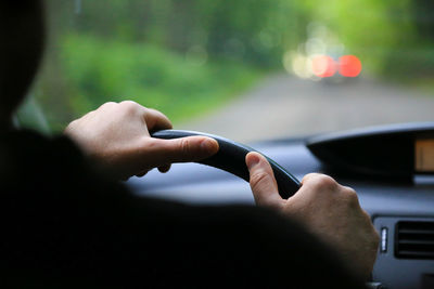 Cropped image of person driving car