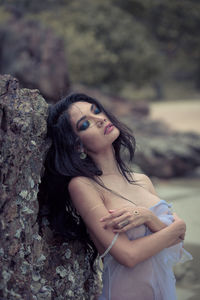 Sensuous woman leaning on rock