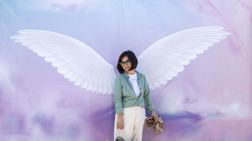 Portrait of woman standing on white wings