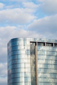 Low angle view of modern building against cloudy sky