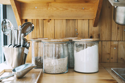 Jars with varieties of flour on shelf at shop