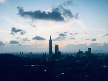 Buildings in city against sky during sunset